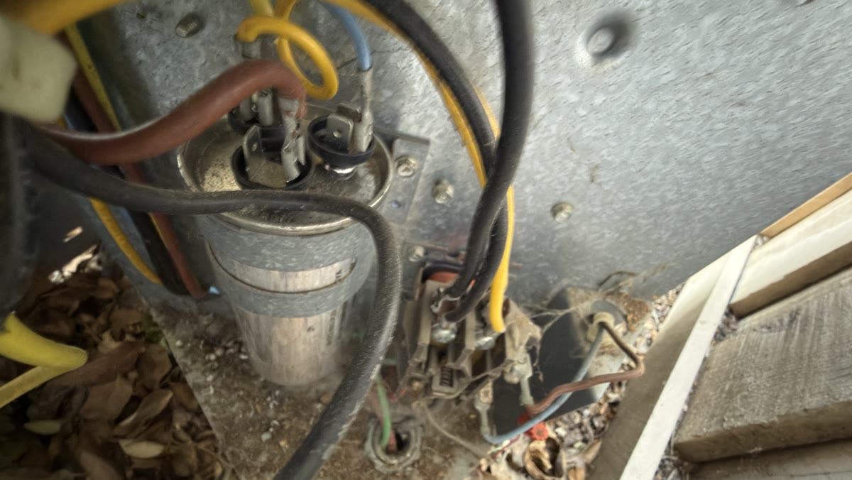 Outdoor AC condenser electrical panel during capacitor replacement